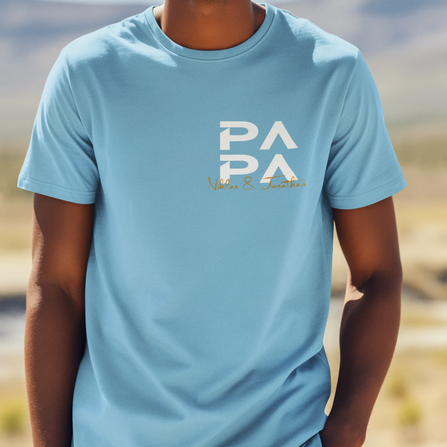 Erwachsener Mann trägt hellblaues T-Shirt mit Aufdruck PAPA Niklas & Jonathan im Freien