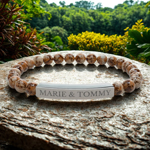 Bracelet avec perles à motifs bruns et plaque argentée gravée « MARIE & TOMMY ».