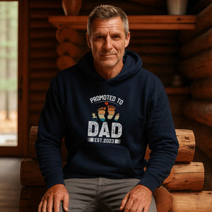UrbanWarriorStore Promoted to Dad Hoodie in Navy Blau, getragen von Mann in Holzhaus