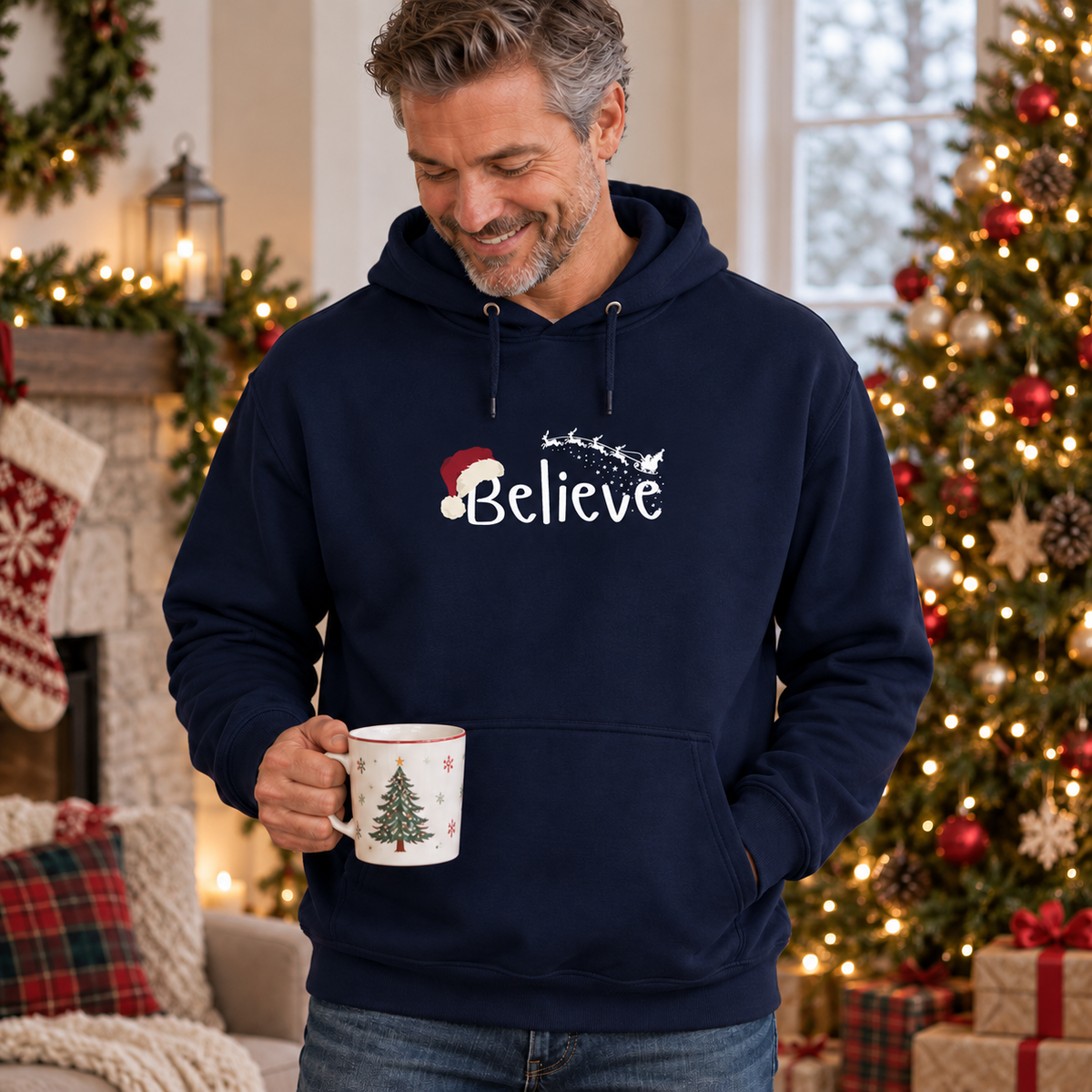 Believe Weihnachts-Hoodie – Navy – weißes Brustmotiv, männliches Model in weihnachtlicher Umgebung