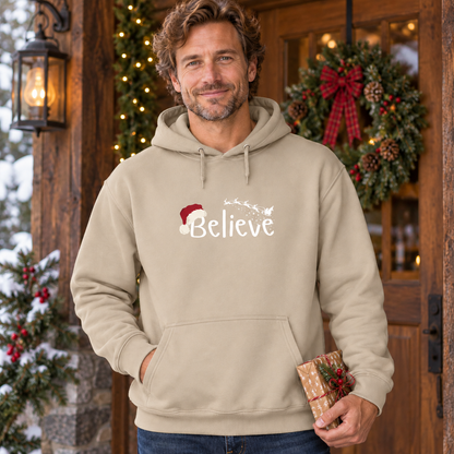 Believe Weihnachts-Hoodie – Sand – weißes Brustmotiv, männliches Model in weihnachtlicher Umgebung