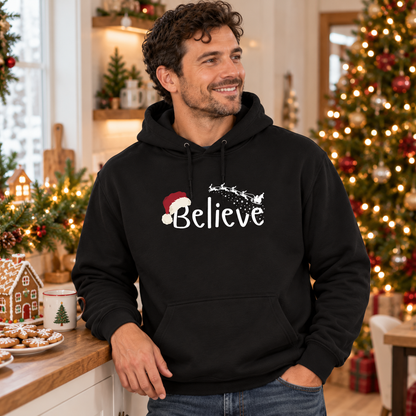 Believe Weihnachts-Hoodie – Schwarz – weißes Brustmotiv, männliches Model in weihnachtlicher Umgebung